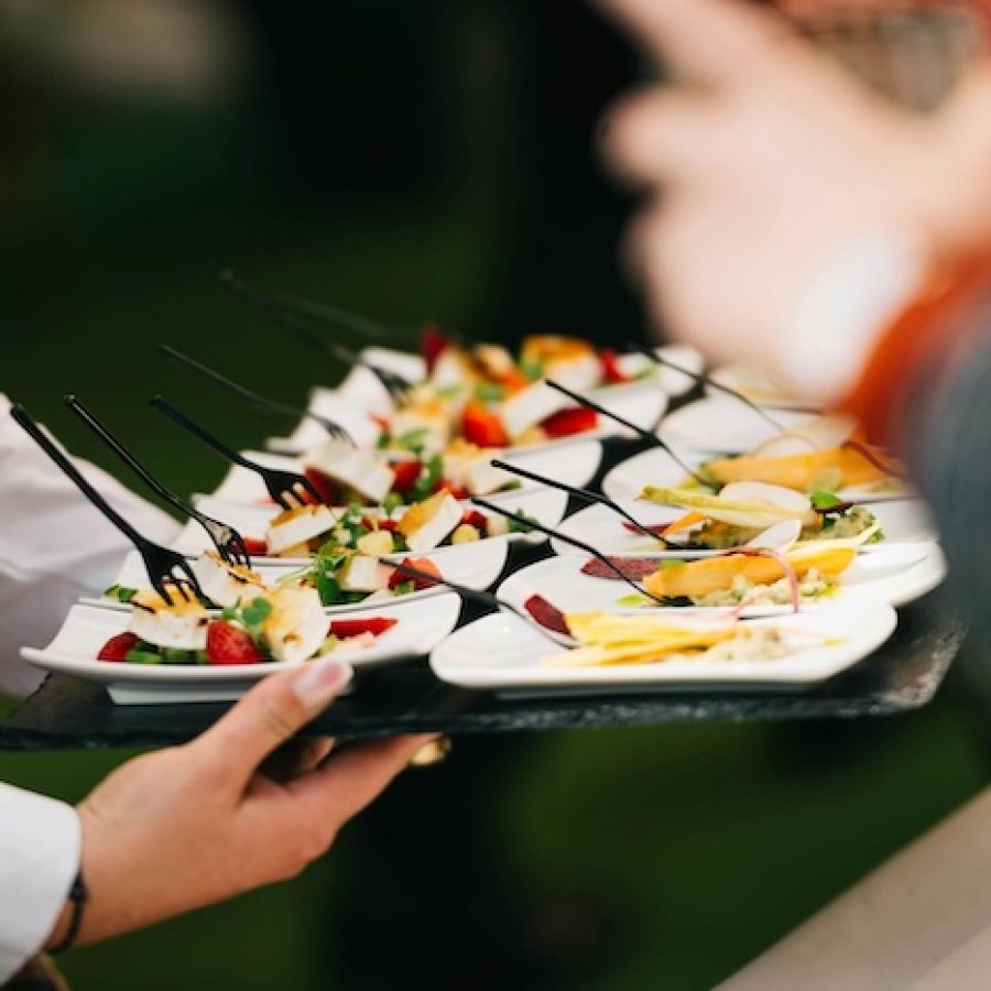 Fingerfood serviert auf einem Tablett von einer Catering-Servicekraft