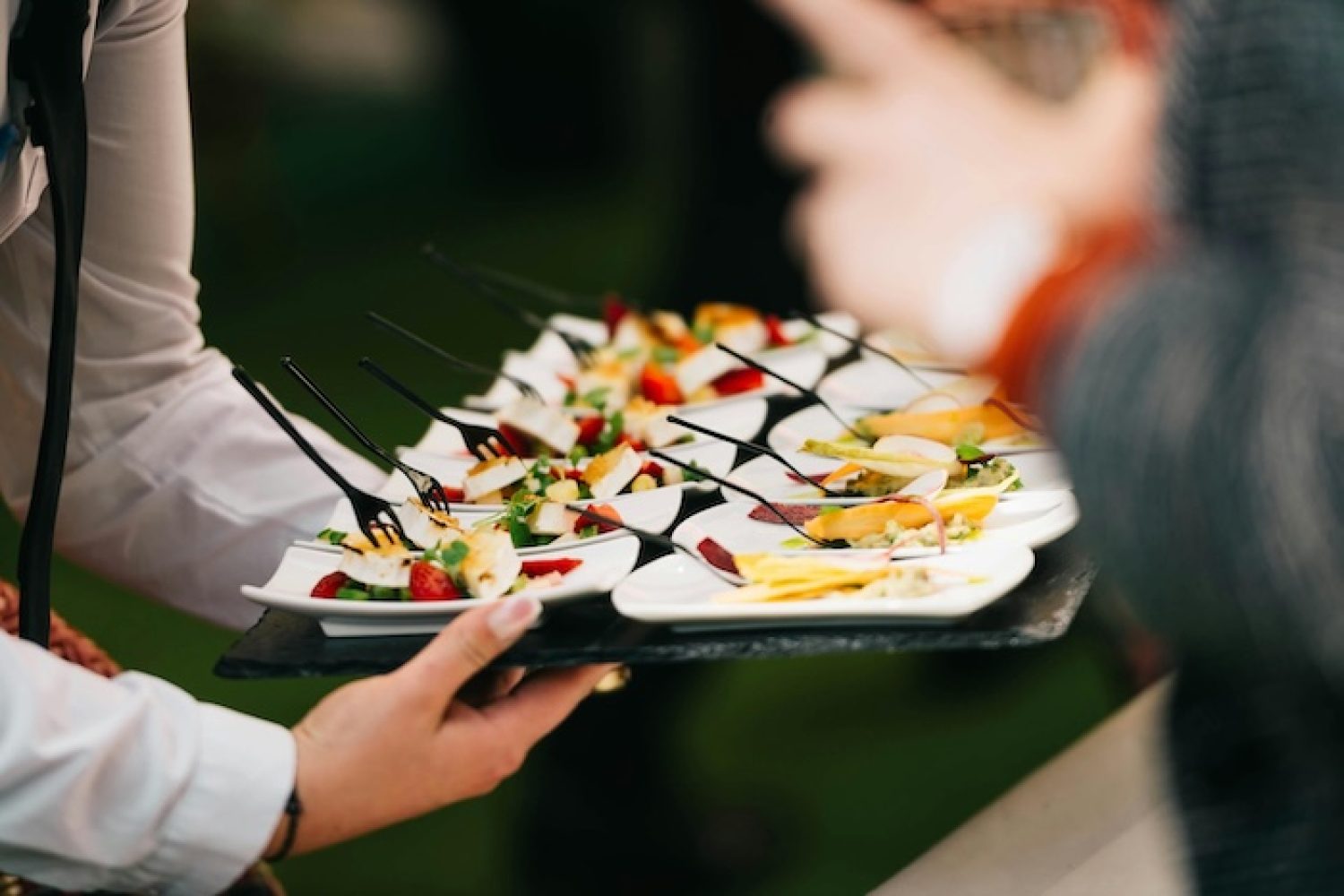 Fingerfood serviert auf einem Tablett von einer Catering-Servicekraft