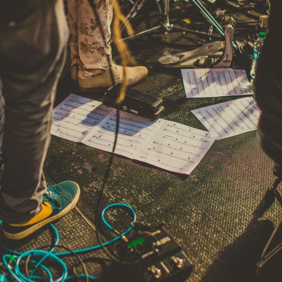 Auf dem Bühnenboden liegende Setlist neben weiterem Bühnenequipment
