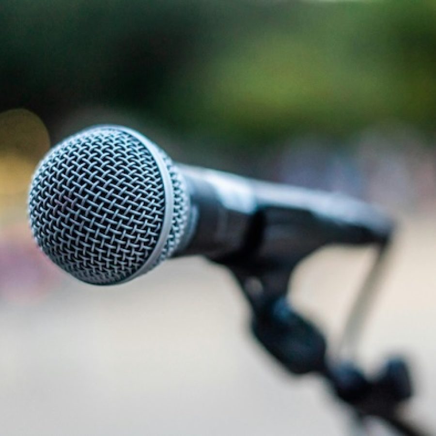 Symbolbild für Eventkommunikation - Mikrofon vor unscharfem Hintergrund