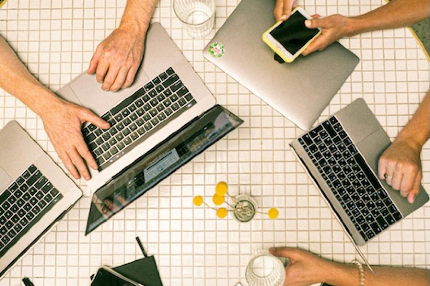 Eventplanung auf rundem Tisch mit diversen Laptops
