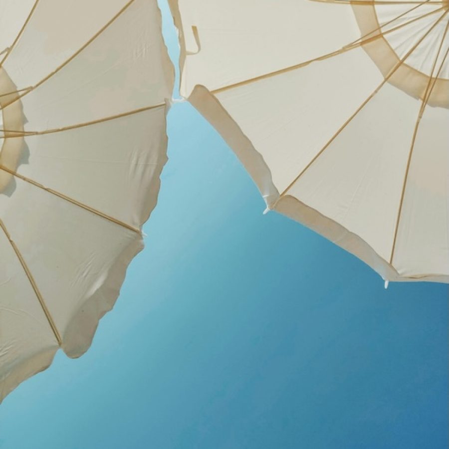 Zwei von unten fotografierte Sonnenschirme mit blauem Himmel als Hintergrund