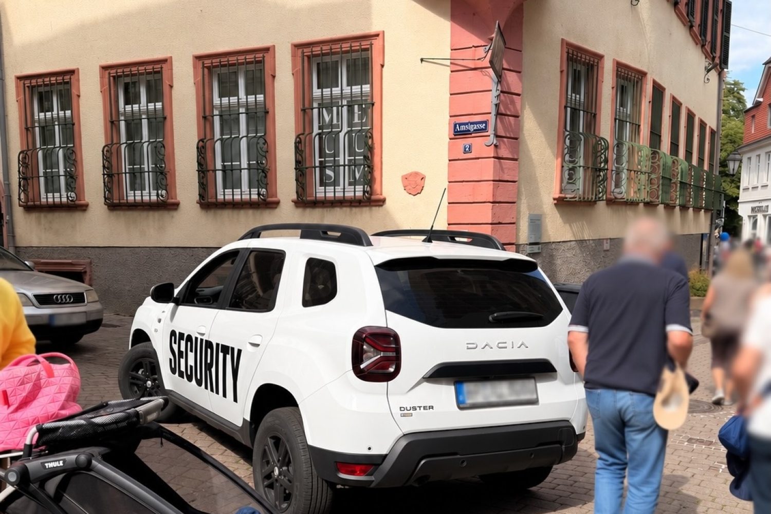 Weißes Fahrzeug mit Aufschrift Security blockiert beim Weinheimer Herbst eine Zufahrt in der Innenstadt, daneben gehen Passanten vorbei