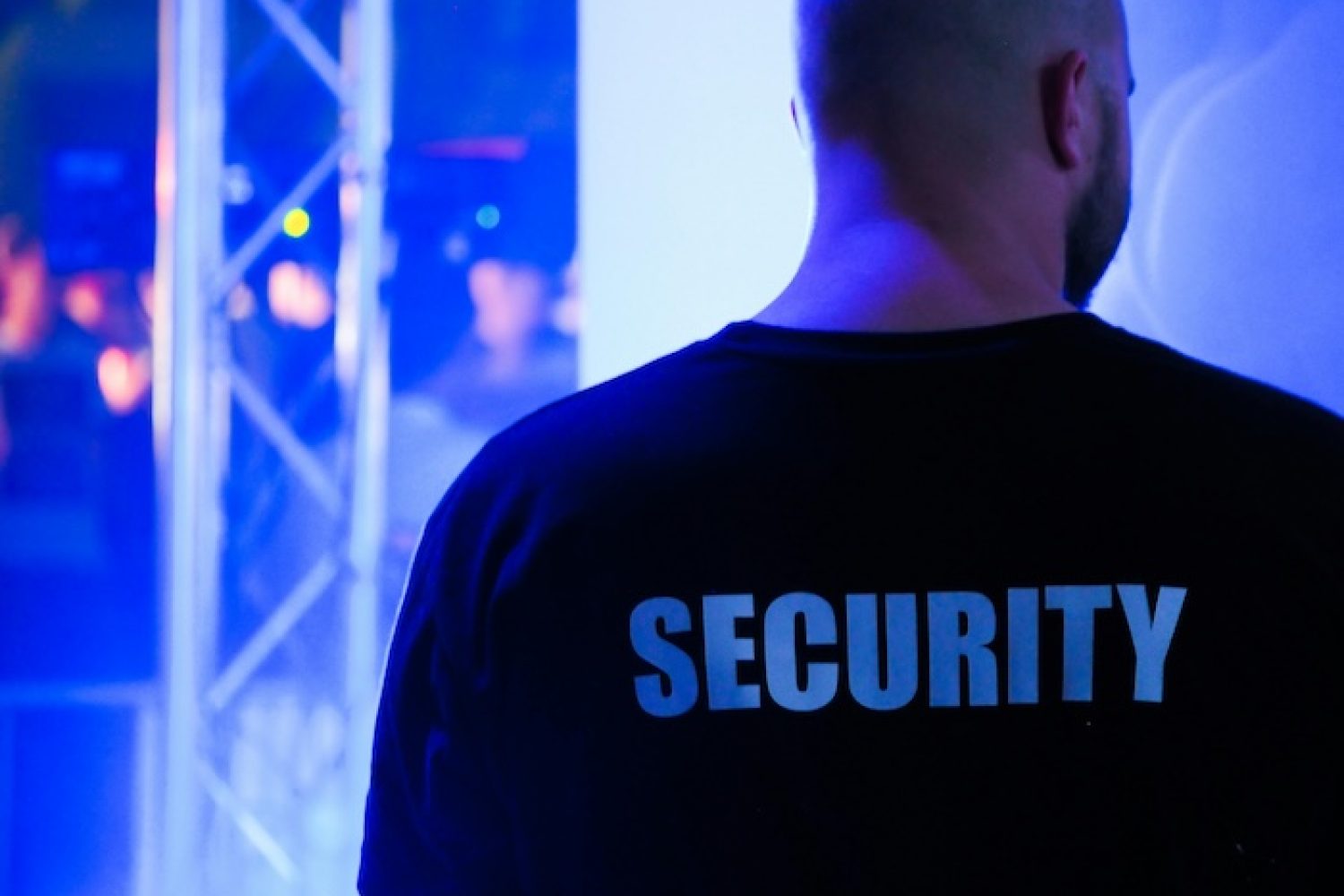 Rückansicht Security-Personal in schwarzem T-Shirt mit der Aufschrift "Security"