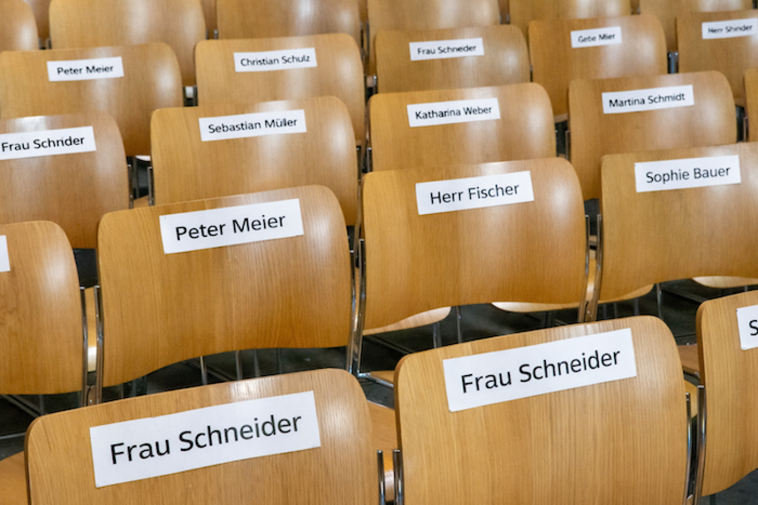 Stuhlreihen mit aufgeklebten Namensschildern